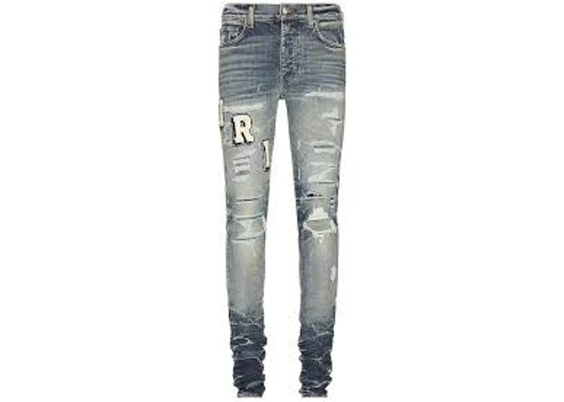 AMIRI Varsity ripped skinny jeans feature a light-blue wash with IRI varsity-style patches on the thigh