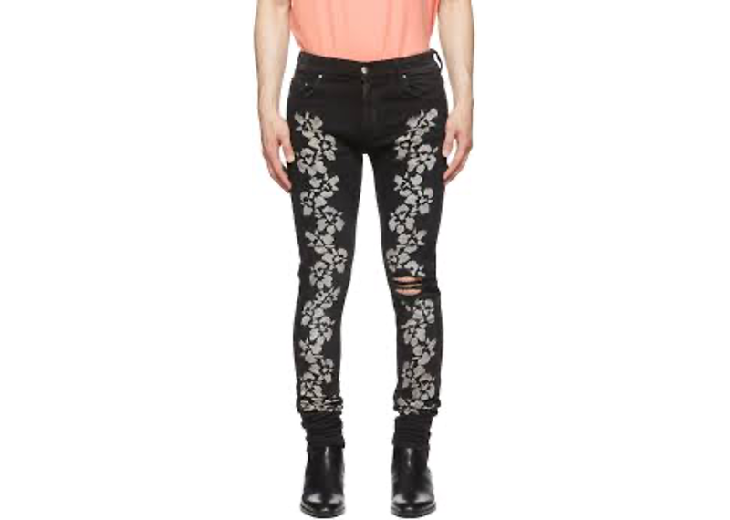 Amiri Black Hibiscus Stencil Jeans featuring a white stenciled flower print, distressing at the knee, and a skinny fit.